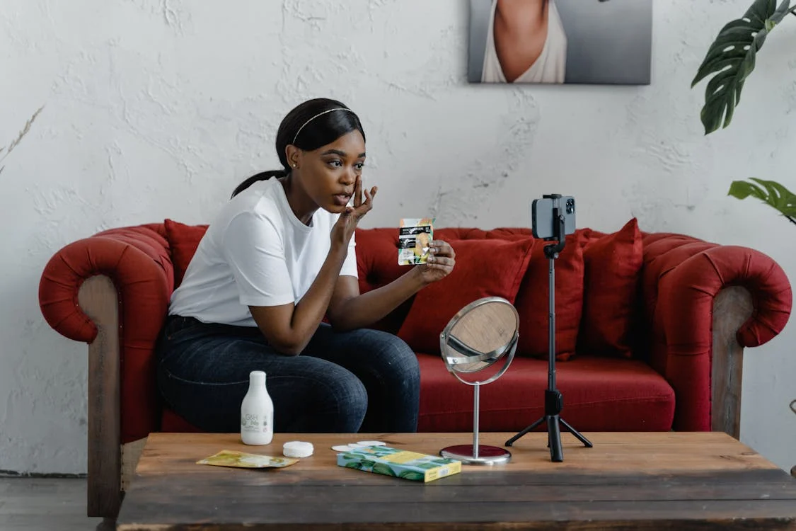 Influenceuse noire qui se filme en train de se maquiller avec son téléphone portable ; influenceuse ivoirienne ; distribution hygiène et cosmétique ; approvisionnement beauty shops